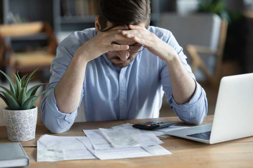 Sad depressed man checking bills, anxiety about debt or bankruptcy