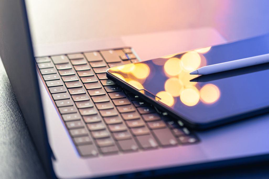 Digital tablet, stylus pen and laptop on the desktop, close up.